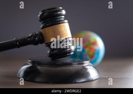 Closeup image of judge gavel and world globe on table. International law concept. Stock Photo