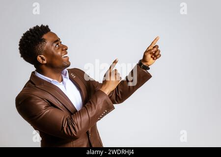 Portrait of happy businessman who is smiling and pointing at blank space on image. Copy space for your text or advert. Stock Photo