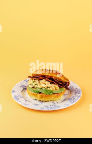 bagel with avocado, sun-dried tomatoes and scramble Stock Photo