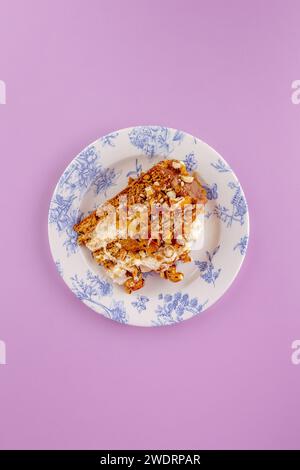 sponge cake with cream and nuts on a yellow background Stock Photo