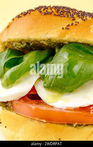 bagel with tomatoes, mozzarella, spinach and pesto sauce Stock Photo