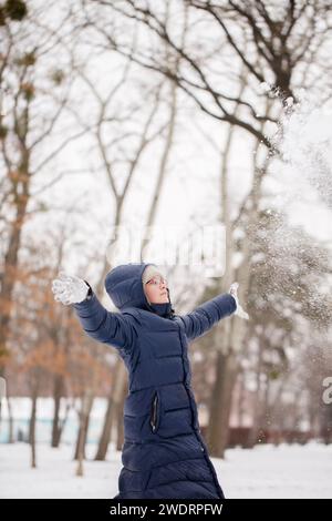 Teenage girl throws up snow Stock Photo