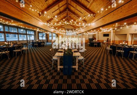 large room set up for wedding reception with dinner tables Stock Photo
