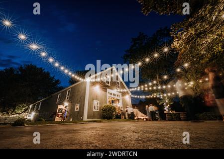 String lights on the outside of a barn at wedding reception, Maine Stock Photo