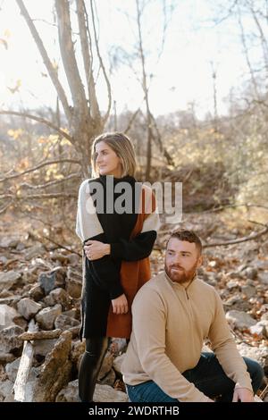 Couple looking into the distance in the woods during fall season Stock Photo