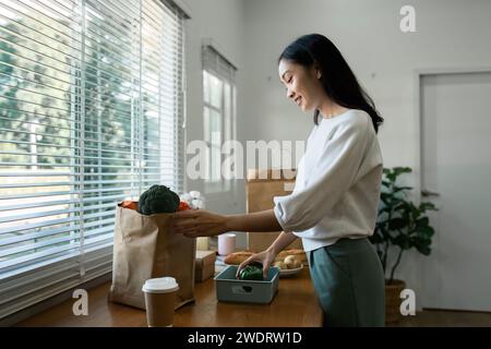 Women stay at home to prepare healthy meals, carrying trays of vegetables to prepare healthy salads at home Stock Photo