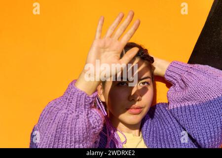 A stylish Korean girl with purple African pigtails in a purple s Stock Photo