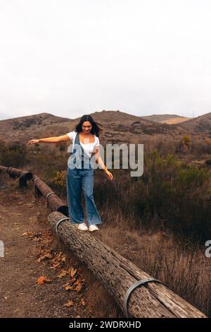 Women walking towards camera on log on hiking trail Stock Photo