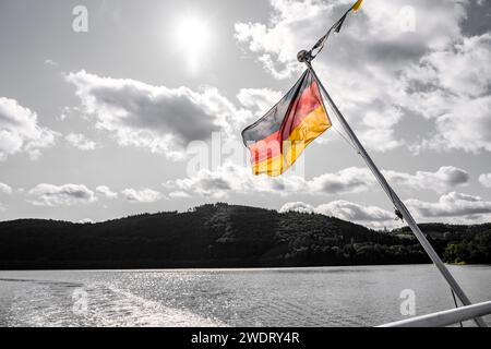 Colored German flag on a boat in front of a black and white background. Stock Photo