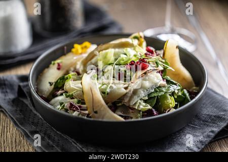 Healthy salad with goat cheese, lettuce, pears and pomegranate. Stock Photo