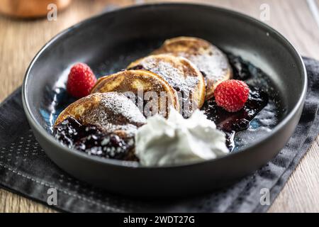 Pancakes with blueberry jam and raspberries in a bowl. Stock Photo