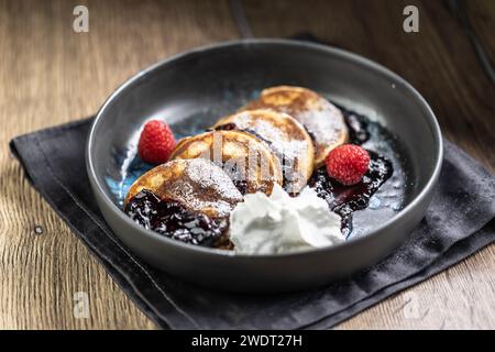 Pancakes with blueberry jam and raspberries in a bowl. Stock Photo