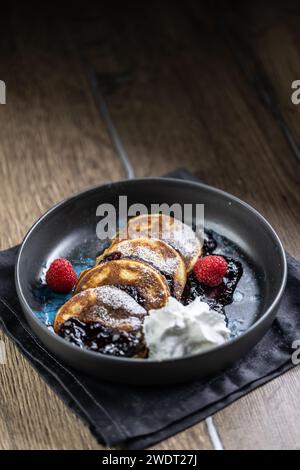 Pancakes with blueberry jam and raspberries in a bowl. Stock Photo