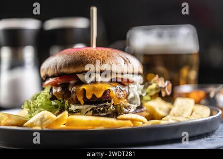 Beef burger with fries and draft beer on a pub or restaurant plate. Stock Photo