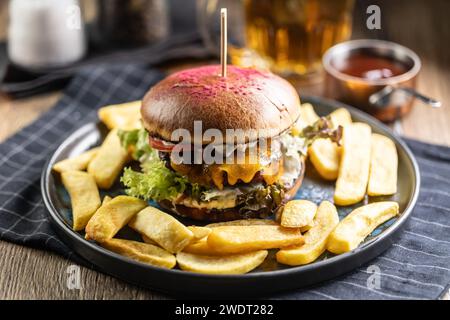 Beef burger with fries and draft beer on a pub or restaurant plate. Stock Photo