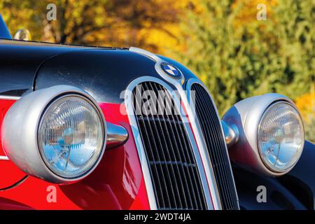 uzhgorod, ukraine - 31 oct 2021: front close-up of a red bmw 321 oldtimer with black hood. sunny outdoor in autumn park Stock Photo