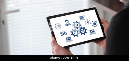 Crm concept shown on a tablet held by a man Stock Photo