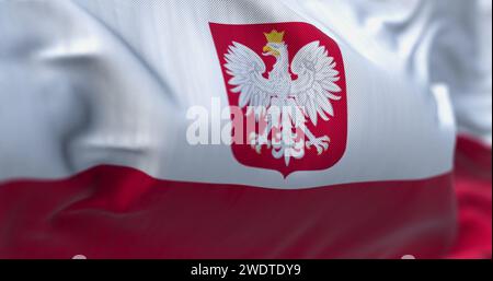 Close-up of Poland national flag waving in the wind. Two horizontal stripes, white on top and red on bottom, with the Polish coat of arms in the cente Stock Photo