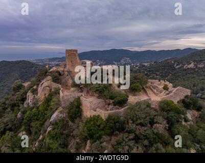 Aerial sunset view of the remains of a small, 11th-century Burriac castle, chapel on a hill, with a modest hike and dramatic views Stock Photo