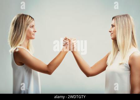 Friendship is the true strength in this amicable arm-wrestling match between two women Stock Photo