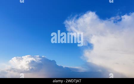 Blue sky with white fluffy clouds in daylight. Natural background. Stock Photo