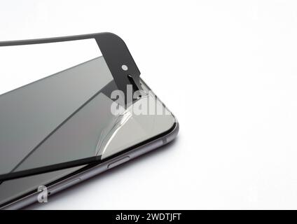 Process of replacing protective glass on smartphone on white background. Safety glass with cracks. Stock Photo