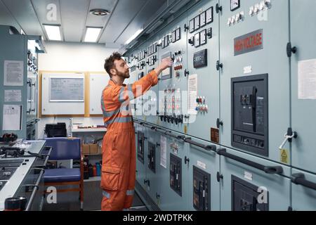 Young engineer working in engine control room on electrical distribution system. Stock Photo