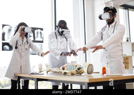 Group of multiethnic scientists, doctors wearing virtual reality digital glasses Stock Photo