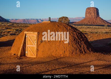 First light on a traditional Navajo hogan in the Monument Valley Navajo Tribal Park in Arizona.   Mitchell Butte is behind. Stock Photo