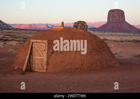 First light of day on the chimney of a traditional Navajo hogan in the Monument Valley Navajo Tribal Park in Arizona.   Mitchell Butte is behind. Stock Photo