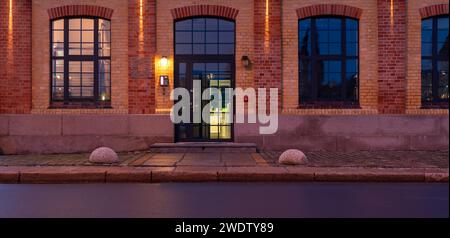 The façade of the historic building together with the granite pavement illuminated by the light of street lamps Stock Photo