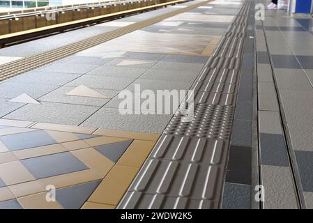 tactile paving for blind handicap on tiles pathway, walkway for blindness people located in train station Stock Photo