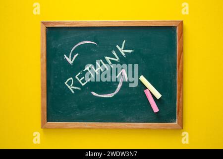 Green chalkboard displaying the word rethink with circular arrows and colorful chalk Stock Photo