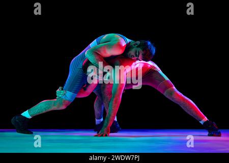 Premium Photo  Two strong wrestlers in blue and red wrestling tights are  making a hip throw on a yellow wrestling carpet in the gym.