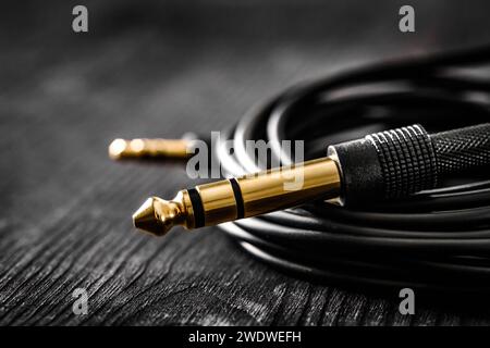 audio cable with Jack and mini jack connectors on a dark table, Stock Photo