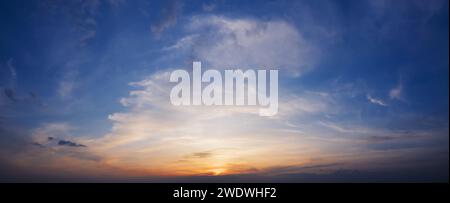 Beautiful blue sky with clouds at sunrise. Panorama of dramatic sky during golden hour. Stock Photo