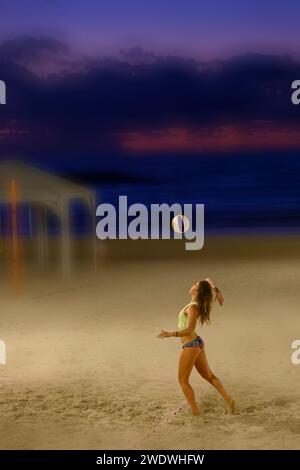Digitally enhanced image of a female beach volleyball player on the sand on the Tel Aviv, Mediterranean beach in the evening at dusk Stock Photo