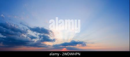 Beautiful dramatic sunset sky with rays of sun shining through the clouds. Stock Photo
