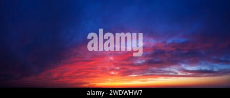 Dramatic sunset sky background. Panorama of twilight sky with clouds. Stock Photo