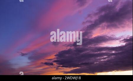 Dramatic sunset sky with clouds during golden hour. Stock Photo