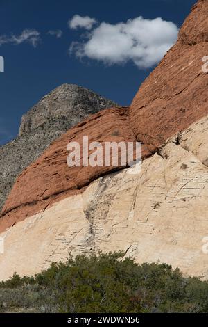 Yellow, red and brown mountains against a blue sky with fluffy clouds. Stock Photo