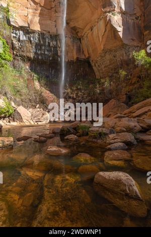 Small waterfall with a small lake and stones in the foreground. Zion National Park Stock Photo