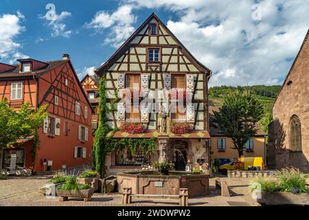 Constantine fountain and half-timbered structure in Kaysersberg, Alsace, France Stock Photo