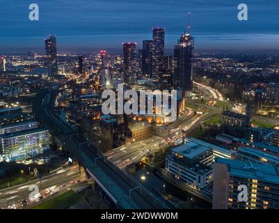 Twilight aerial photograph at rush hour of Mancunian Way, rail bridges, Castlefield, New Jackson and the wider Manchester city centre, UK Stock Photo