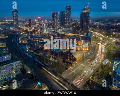 Twilight aerial photograph at rush hour of Mancunian Way, rail bridges, Castlefield, New Jackson and the wider Manchester city centre, UK Stock Photo