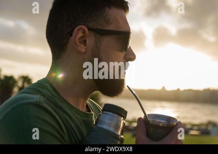 Man drinking chimarrao, mate (an infusion of yerba mate with hot water) at sunset in uruguay Stock Photo