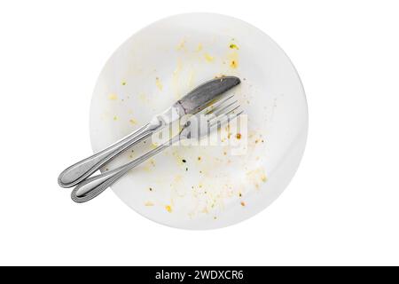 Empty dirty plate with leftovers, knife and fork isolated on white background Stock Photo