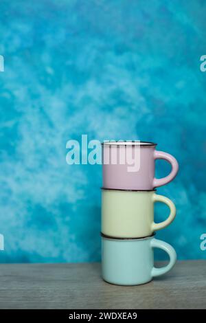 Colorful mugs on a blue background. Minimalism. Stock Photo