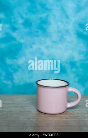 pink mug on a blue background. Minimalism. Stock Photo