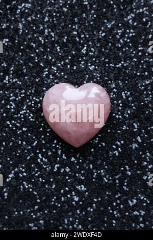 rose quartz heart on black glitter background, valentine's day concept. Stock Photo